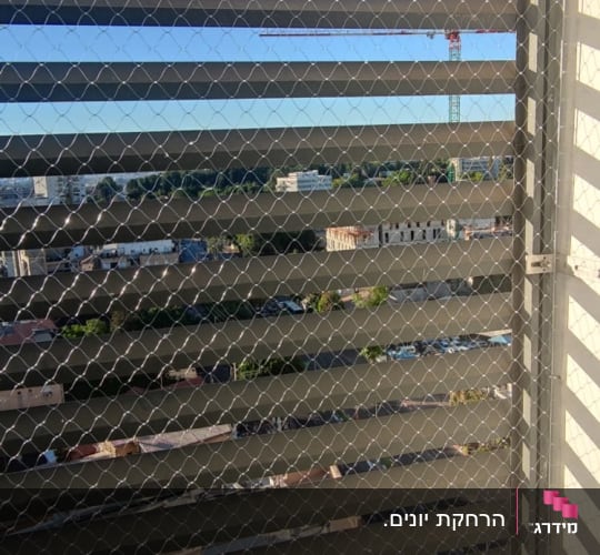 רשת מתכת מותקנת על חלון למניעת כניסת יונים